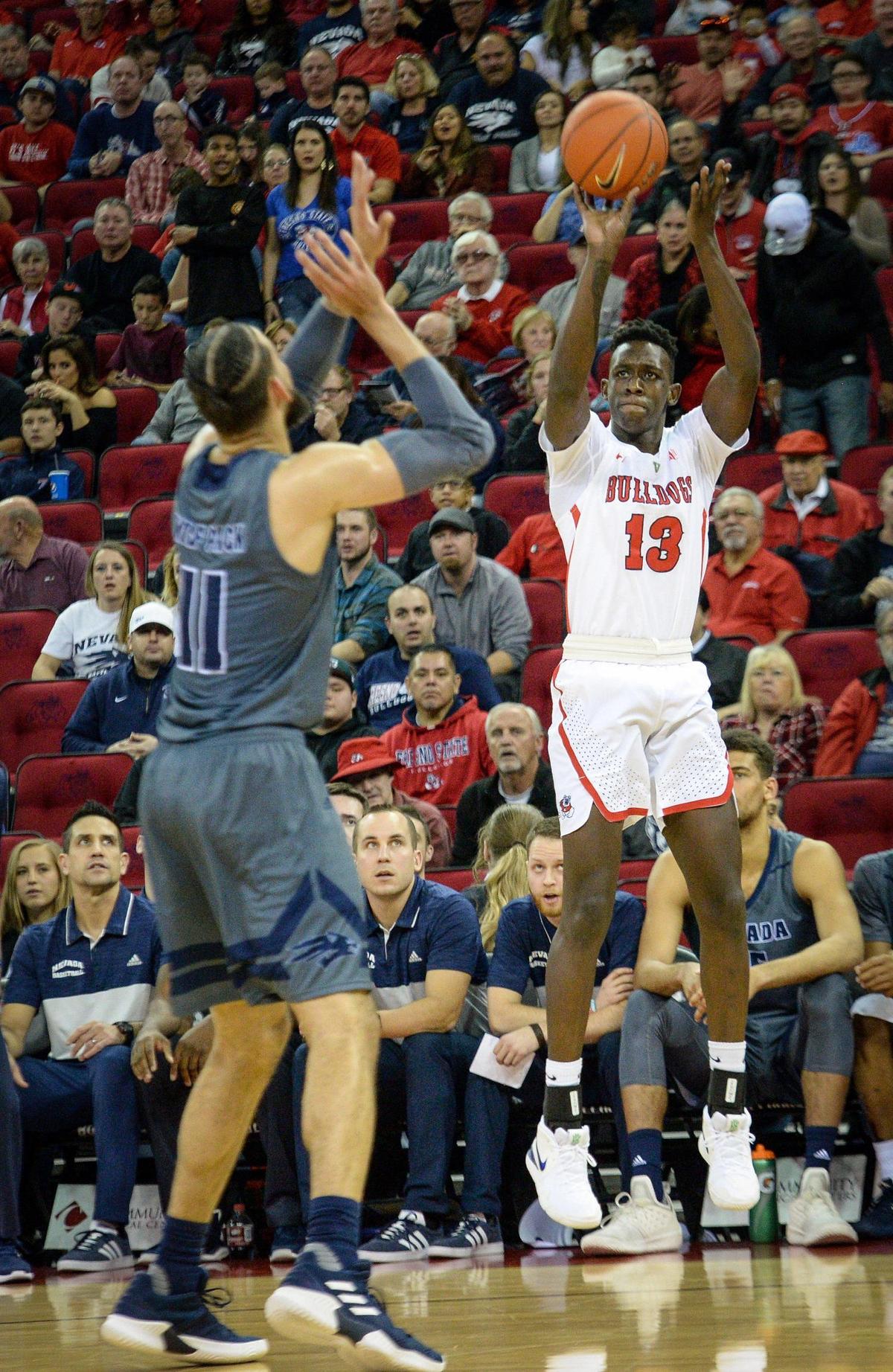 Fresno State forward Aguir Agau, right, takes a three-point shot while defended by Nevada’s Cody Martin during the Bulldogs 74-64 loss to the Wolf Pack at the Save Mart Center on Saturday, Jan. 12, 2019. Agau scored three points, the only points Fresno State got off its bench in the loss.