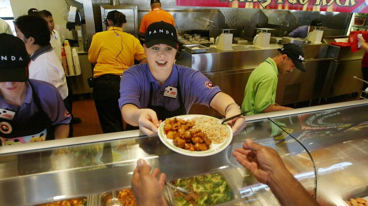 A Panda Express employee serves a customer in Hanford. The Los Angeles-based Chinese American fast-food chain closed a store in Lincoln due to a coronavirus outbreak affecting its staff.
