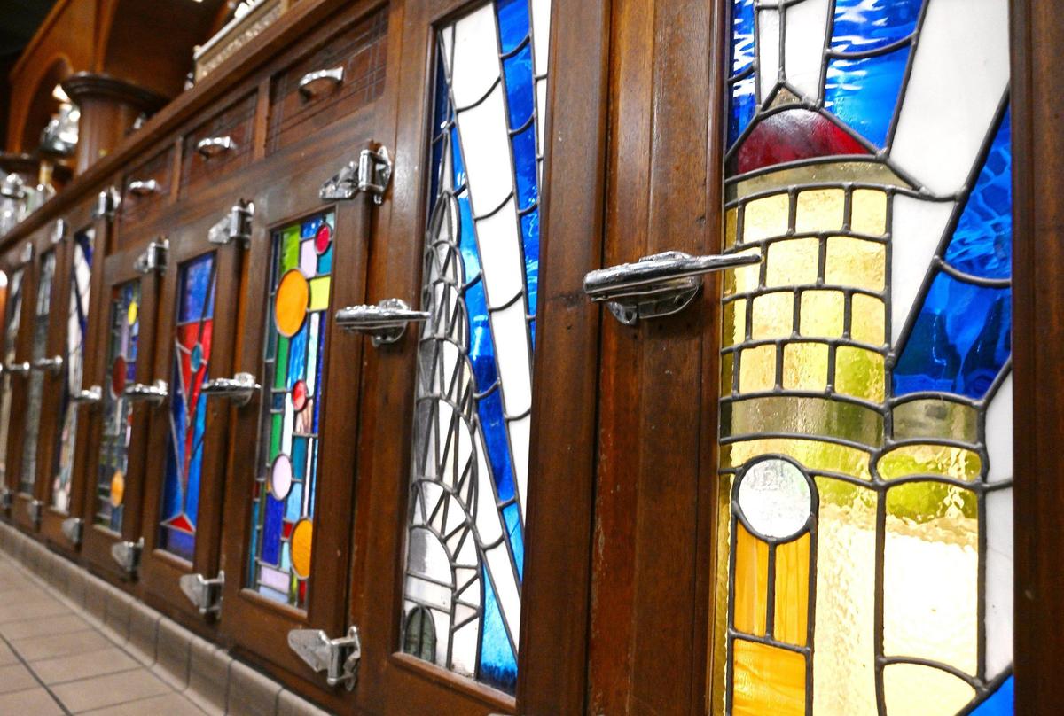 Stained glass doors at Cosmopolitan Tavern & Italian Grill’s backbar are recreations of the originals showing famous landmarks as well as local sites like the Water Tower, right. Photographed in downtown Fresno Friday, Oct. 25, 2024.