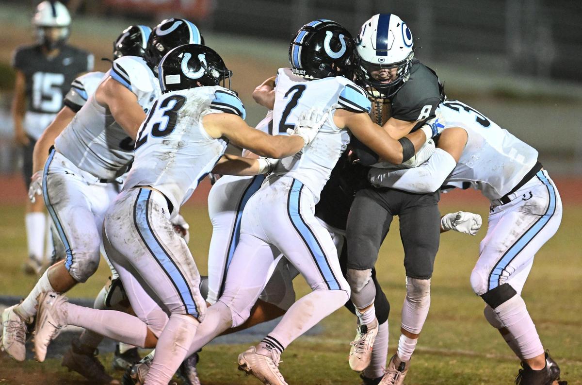 Central Valley Christian’s Micah Baden, right, runs into a wall of Clovis North defenders during their game at CVC on Friday, Sept. 8, 2023.