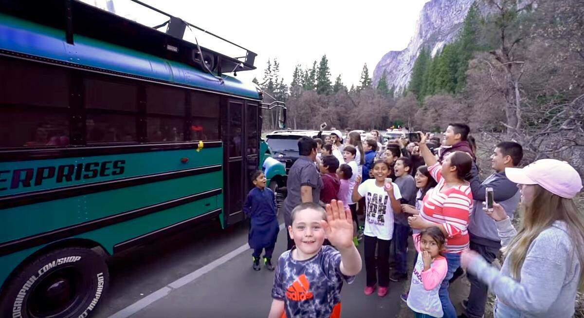 A screenshot from a YouTube video posted by Logan Paul on April 2, 2018 of children gathering outside his 'Cool Bus' in Yosemite National Park over the weekend.