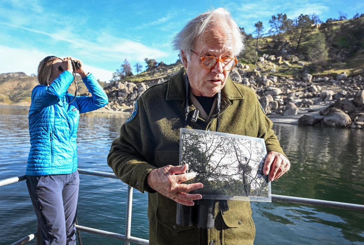 Millerton Lake eagle tour docent Mike Smith shows a photo of a pair of nesting bald eagles during an eagle tour at the lake on Sunday, Feb. 3, 3025.