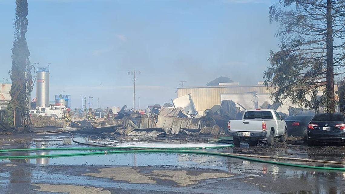 Fire crews work on clean up after a commercial building burned down at agriculture company in southwest Fresno Sunday, Oct. 17, 2021.