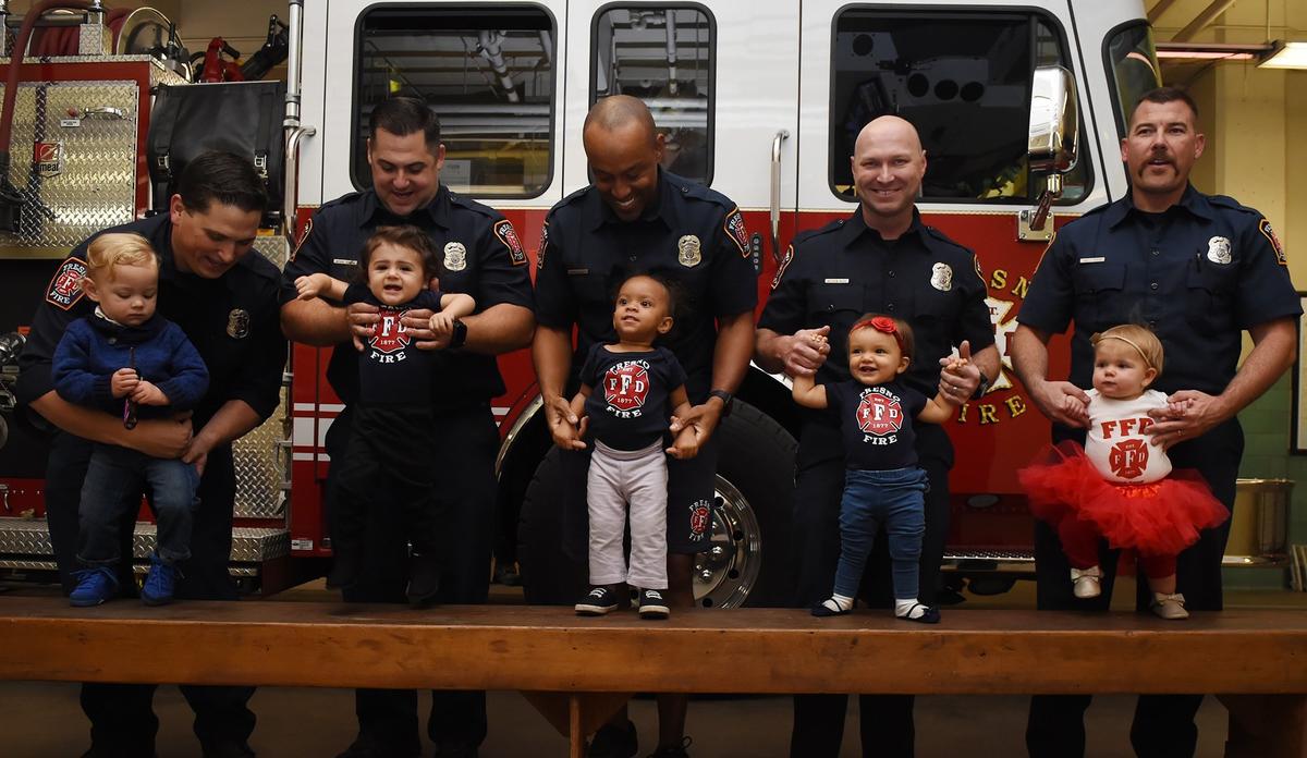 Pictured, from left: Josh Henry holds son, Jett Henry, 18 months old; Anthony Troncale holds daughter, Elisa Troncale, 16 months; Michael McIntyre holds daughter, Myla McIntyre, 19 months; Matt Raupp holds daughter, Elizabeth Raupp, 12 months; and James Perkins holds daughter, Emma Perkins, 11 months, at Fresno Fire Station 3 on Monday, Nov. 12, 2018 in Fresno.