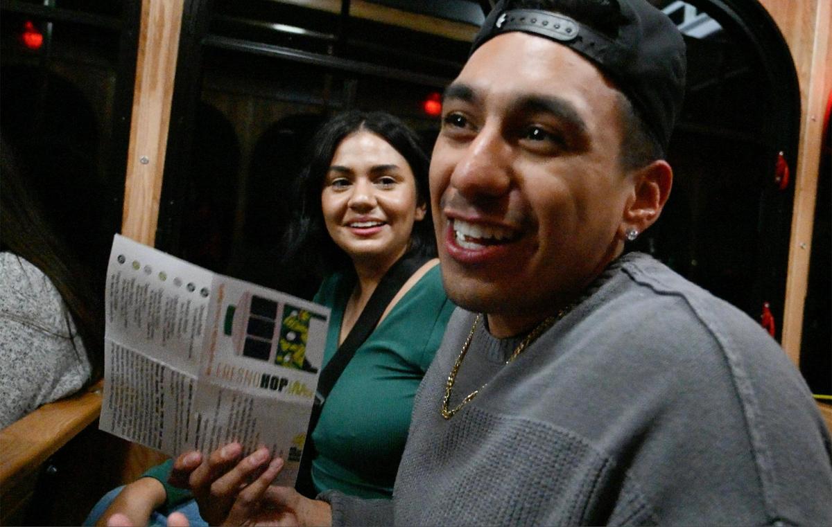Taylor Mendoza, a la izquierda, escucha mientras Daniel González explica cómo los dos se enteraron del nuevo servicio gratuito de trolebús FresnoHOP de la ciudad de Fresno y viajaban en él desde Campus Pointe hasta el Tower District, la noche del viernes 10 de noviembre de 2023, en Fresno.