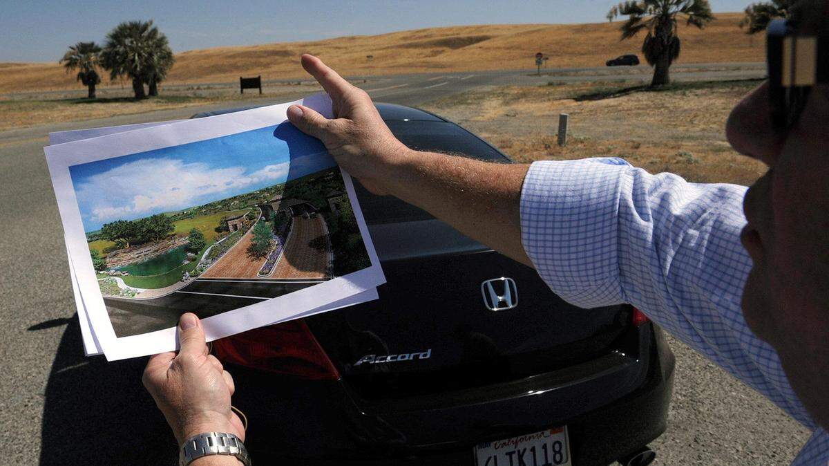 Standing at the entrance to Fresno County’s Lost Lake Park, Dennis Bacopulos, a developer proposing the 2,500-home Friant Ranch development in the foothills just south of the town of Friant, holds an artist’s rendering and points out how the development will appear in the hills across Friant Road.