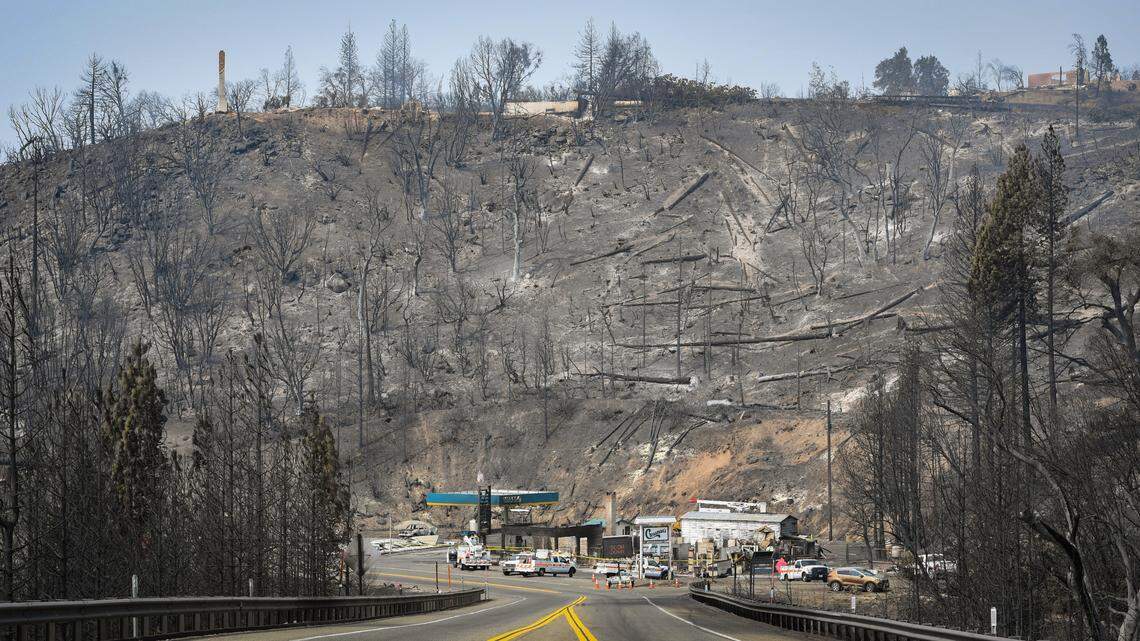 Blue skies begin to emerge after days of heavy smoke from the Creek Fire as seen behind the burned remains of Cressman’s General Store and the charred hillside near the four-lane at Pine Ridge on Saturday, Sept. 19, 2020.