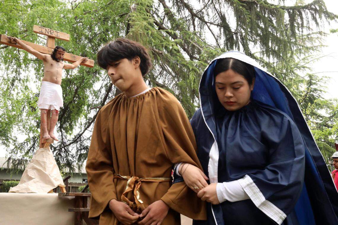 Luis Alberto Hernández as Jesús in the background with 15-year-old son Gael Romero as Juan and 19-year-old Rita García as María, the mother of God during the Live Stations of the Cross at Saint Anthony Mary Claret Catholic church on Good Friday, March 29, 2024, in Fresno.