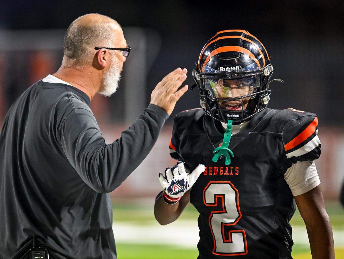 Central East's Brandon Smith is congratulated by coach Kyle Biggs after scoring a touchdown against Clovis East during their playoff game at Deran Koligian Stadium in Fresno on Friday, Nov. 7, 2025.