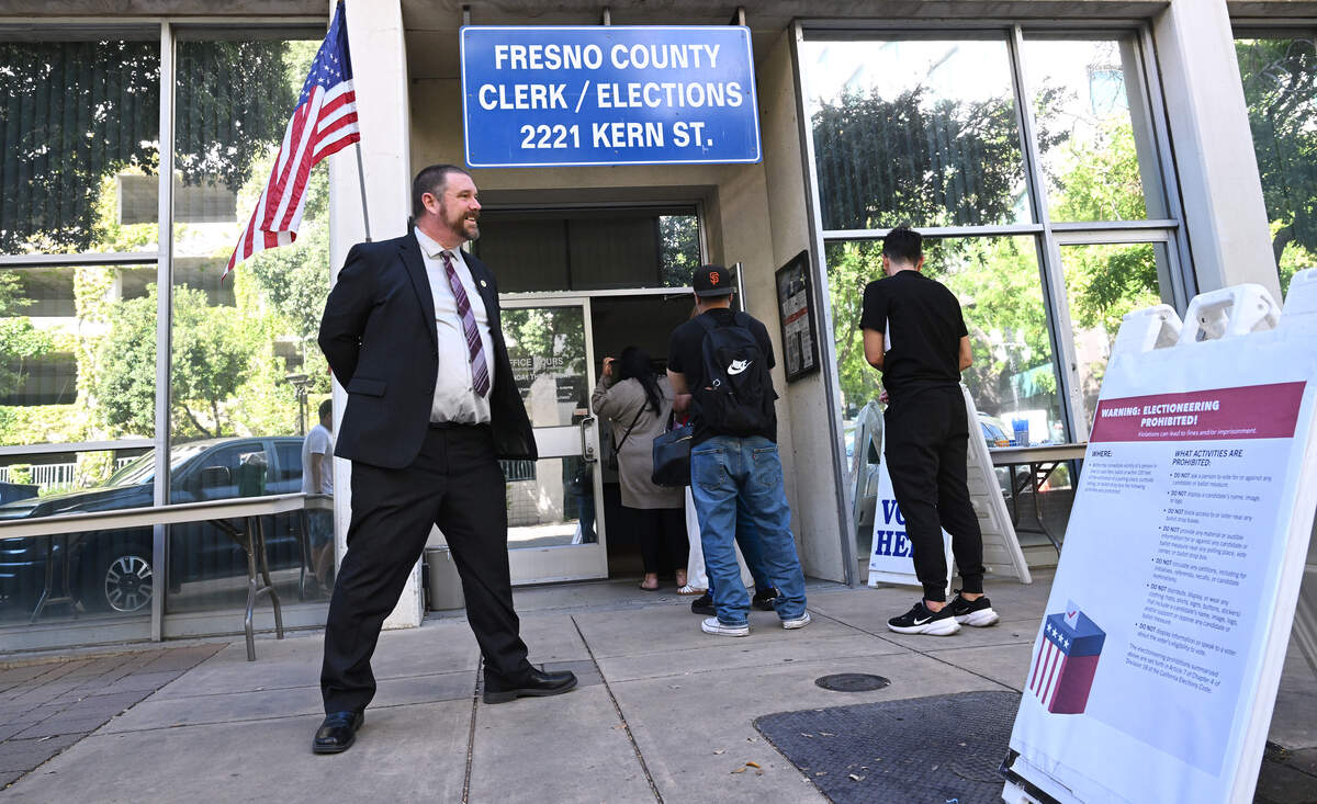 James A. Kus, Fresno County Clerk and Registrar of Voters, left, stands outside observing voters arrive on Election Day Tuesday, June 2, 2026 in downtown Fresno.