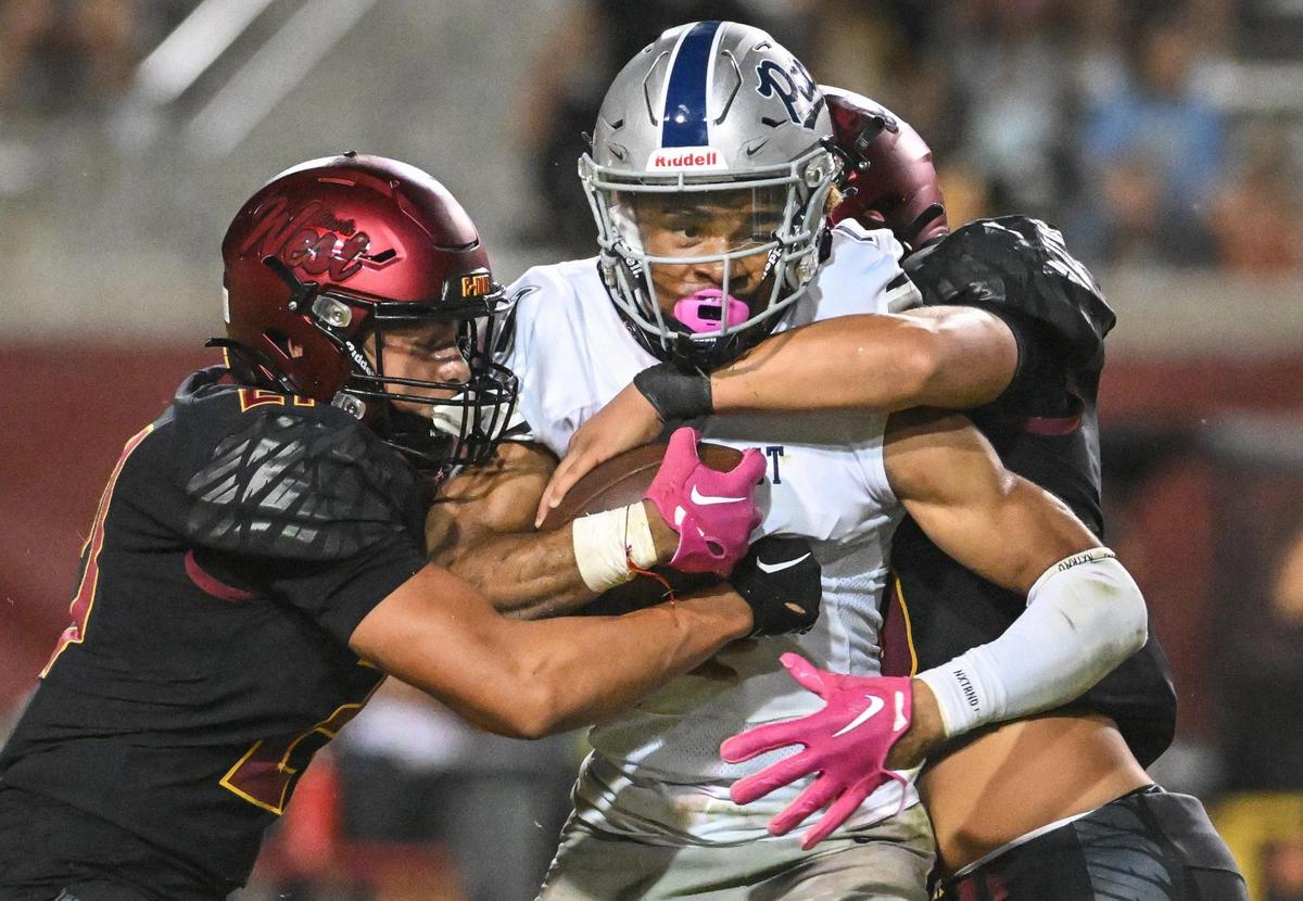 Clovis East’s Tommy Nix gets wrapped up while trying to squeeze through the Clovis West defense during their game at Veterans Memorial Stadium in Clovis on Friday, Oct. 6, 2023.
