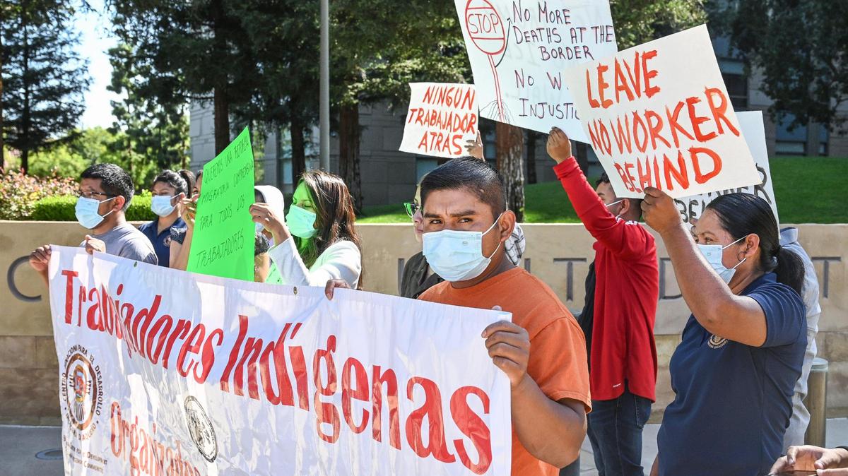 A group opposing the federal Farm Workforce Modernization Act hold up signs and speak out against the act saying it doesn’t do enough outside the Federal Building in downtown Fresno on Monday, Aug. 29, 2022.