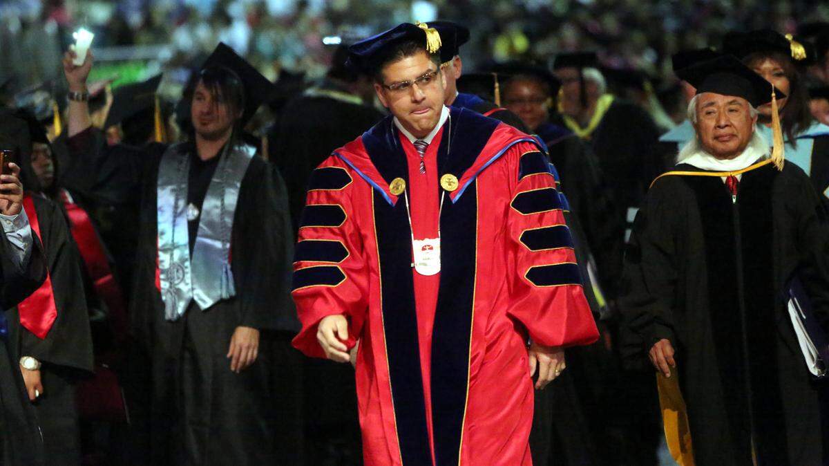 Scenes from the 103rd commencement ceremony for Fresno State University in 2014. About 1,300 graduates took part in the ceremony in front of 10,235 specatators. 4,675 bachelor's, 890 master's and 69 doctorates. 37 students achieved perfect 4.0 GPAs. Dr. Joseph I. Castro, Fresno State president, walks during his first graduation ceremony at the university.