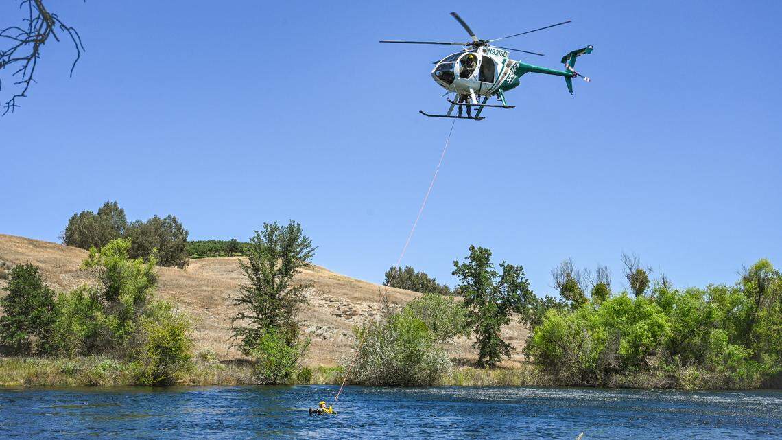 The Fresno Sheriff’s Department’s Eagle One helicopter drops a rescue sling for Trevor Marriott, a Fresno State criminology 108 reserve program participant with the Fresno County Sheriff’s Department, while participating in swift water rescue training on the San Joaquin River at Lost Lake park on Monday, June 6, 2022.