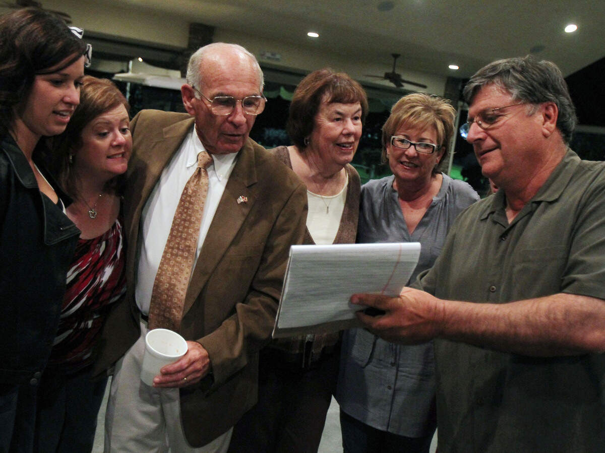 In this file photo from Election Night in 2010, Phil Larson, second from left, after being interrupted while having his photo taken with family members, leans in to hear Ken Abrahamian share polling numbers in Larson’s race for Fresno County Supervisor.