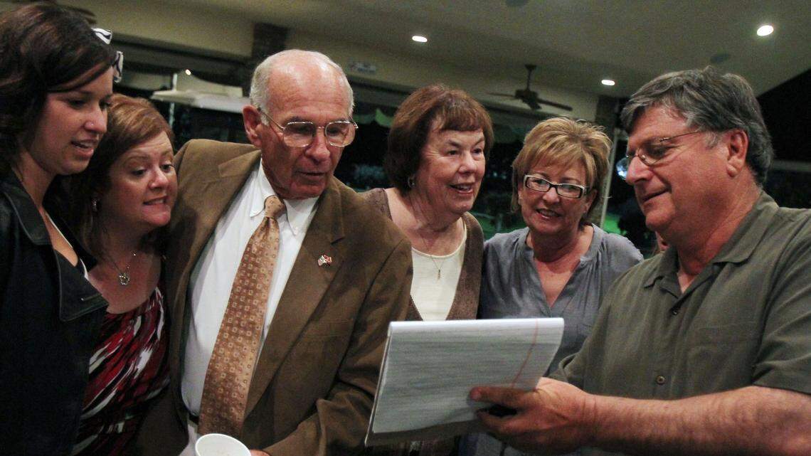 In this file photo from Election Night in 2010, Phil Larson, second from left, after being interrupted while having his photo taken with family members, leans in to hear Ken Abrahamian share polling numbers in Larson’s race for Fresno County Supervisor.