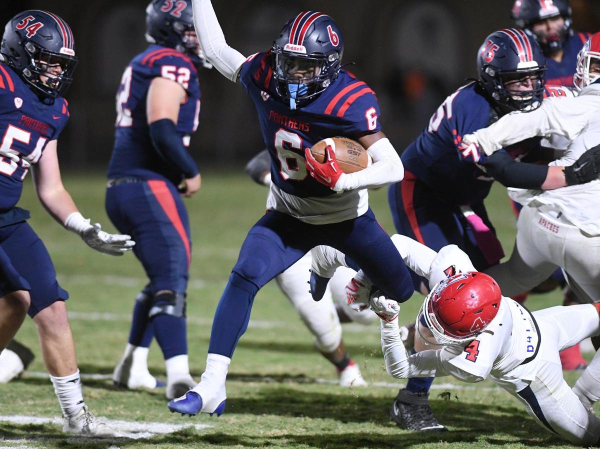 San Joaquin Memorial’s Donovan Harris, center, kicks through Sanger’s Jaden Woo, bottom right, as he runs for a touchdown Friday, Oct. 28, 2022 in Fresno. Memorial led 28-14 at halftime.