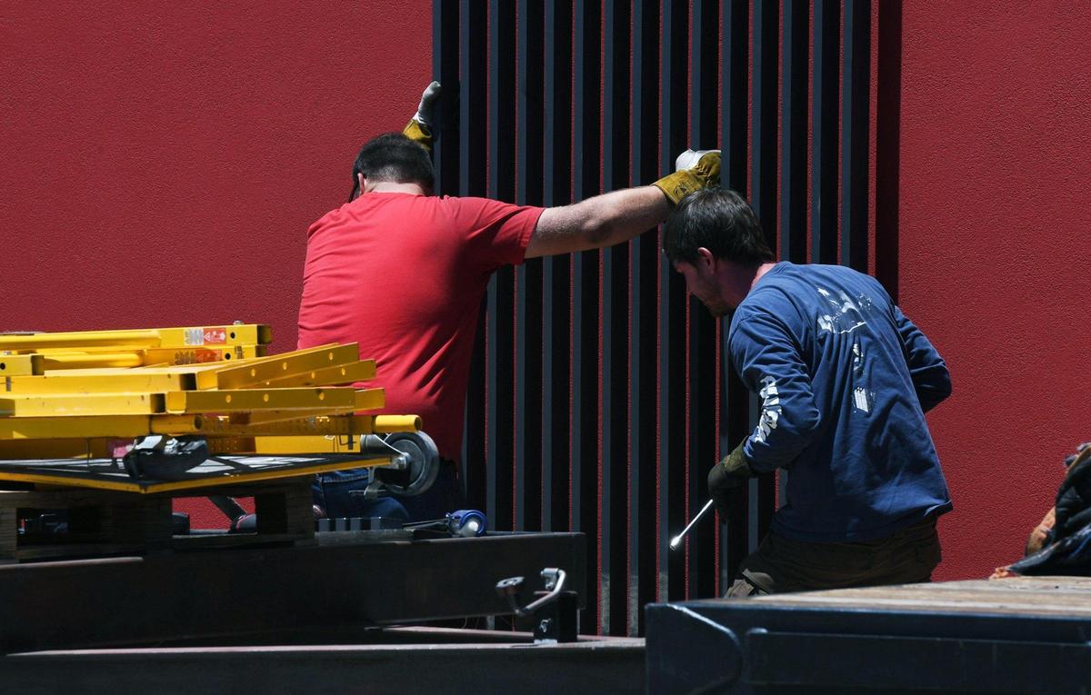 Construction workers affix decorative bars near the drive thru window at a new Chipotle being built at Brawley near Herndon which will feature “Chipotlanes” for more efficient drive-thru service. Photographed Wednesday, June 15, 2022 in Fresno.