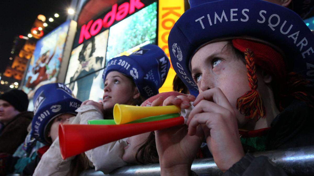 Jarlath Byrne, 10, from Rockville Centre, New York, right, blows his horn as he takes part in the New Year’s Eve festivities in New York’s Times Square Friday Dec. 31, 2010.