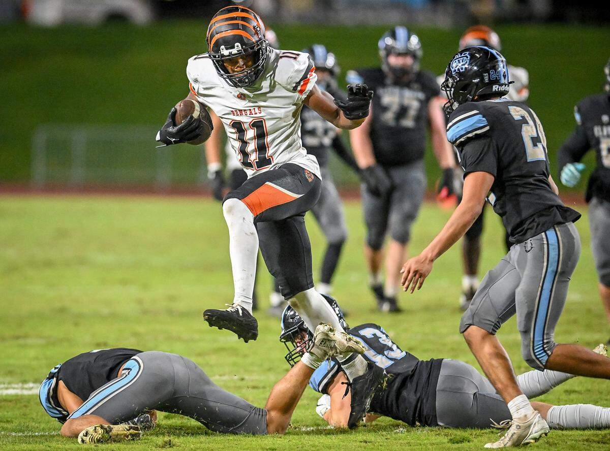 Central East's Titus Thomas leaps over Clovis North players while taking the ball upfield late in the game during their TRAC opener at Veterans Memorial Stadium in Clovis on Thursday, October. 2, 2025.