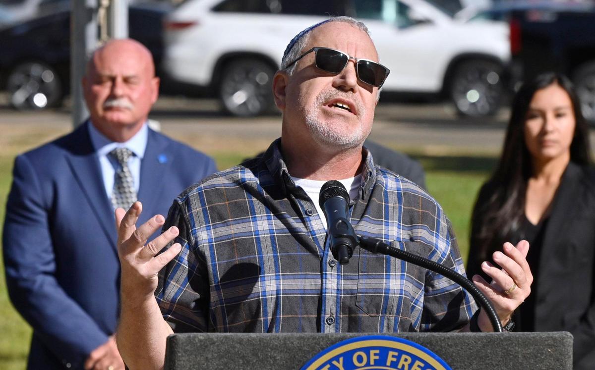 Rabbi Rick Wiener of Temple Beth Israel raises his hands in a prayer as the City of Fresno raised an Israeli flag in solidarity with Israel at Eaton Plaza Thursday, Oct. 12, 2023 in downtown Fresno.
