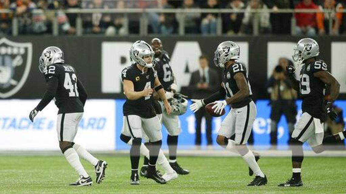 Oakland Raiders quarterback Derek Carr (4) celebrates with Gareon Conley (21) after he made an interception during the second half of an NFL football game against the Chicago Bears at Tottenham Hotspur Stadium, Sunday, Oct. 6, 2019, in London.