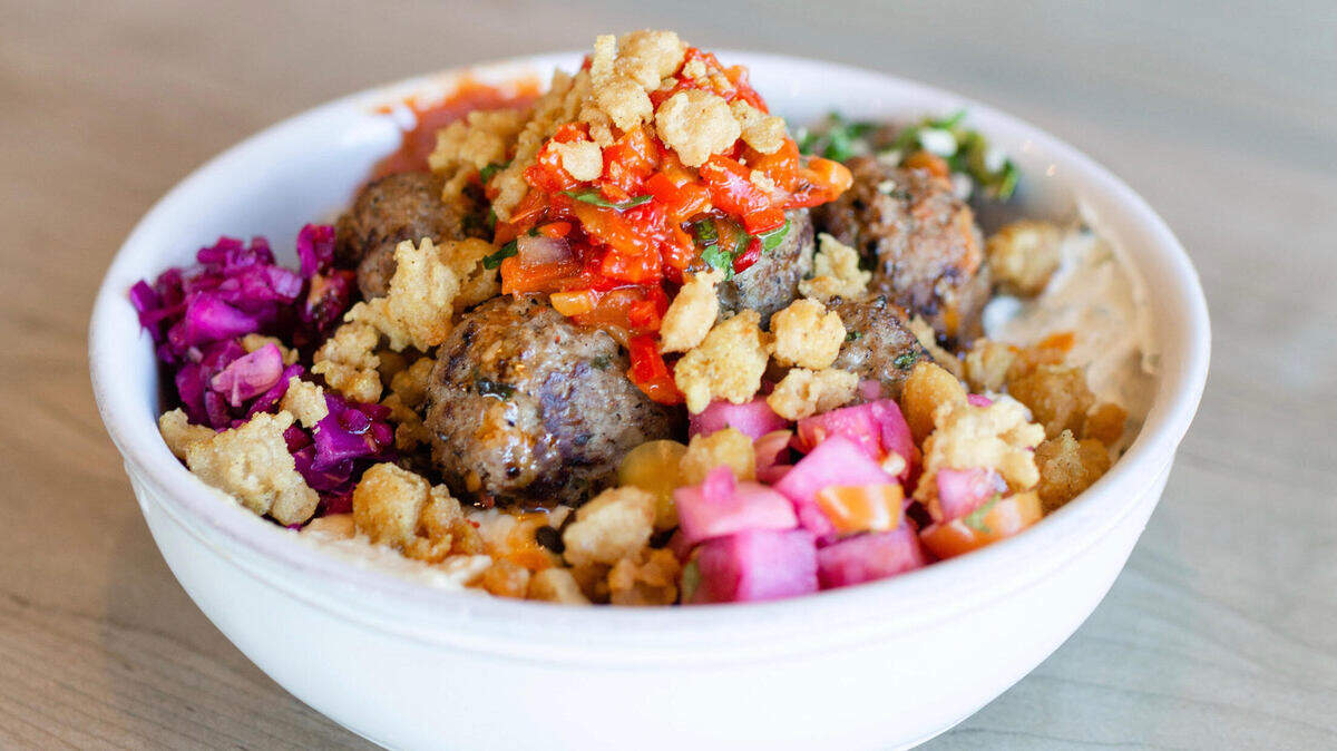 The custom bowl from newly opened Mayd Modern Mediterranean in this handout photo contains basmati rice, Moroccan lamb meatballs, organic hummus, smoked tomato harissa, beet slaw, crispy chickpeas and more.
