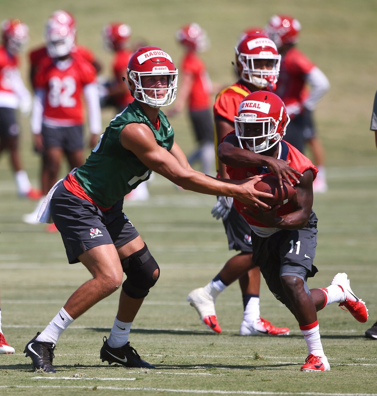 Fresno State quarterback Hunter Rauet, left, hands off to  running back Dejonte O’Neal, right, during Fresno State’s first football practice Friday, Aug. 3, 2018 in Fresno.