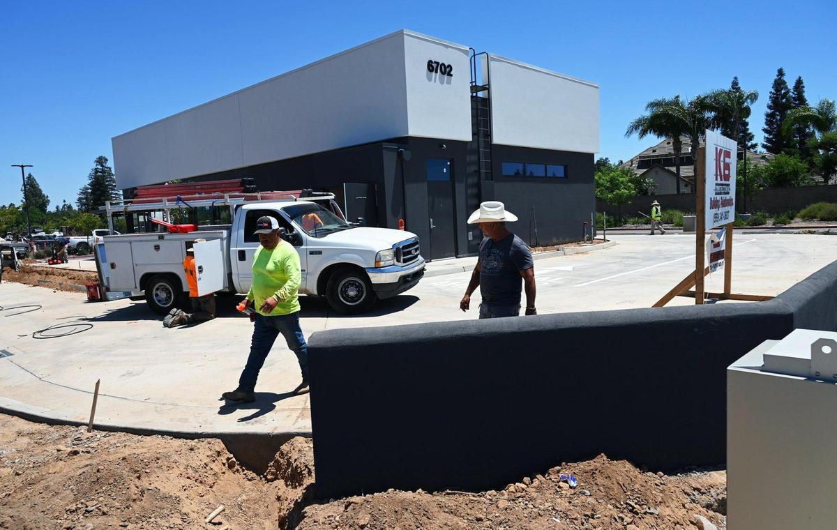 Workers walk around the perimeter of a new Chipotle being built at Brawley near Herndon which will feature “Chipotlanes” for more efficient drive-thru service. Photographed Wednesday, June 15, 2022 in Fresno.