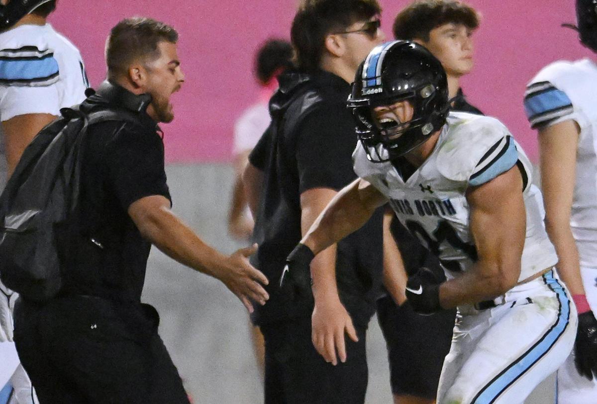 Clovis North’s Jackson Cinfel, right, celebrates his first-quarter touchdown against Clovis West with sideline coaches and players Friday, Oct. 13, 2023, in Clovis.