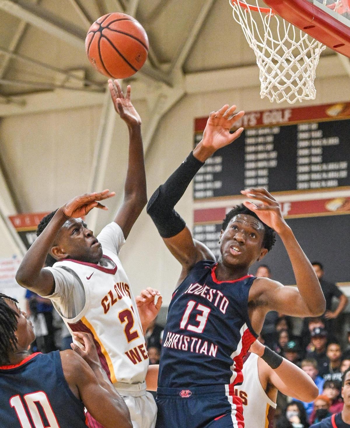 Clovis West’s DJ Stickman, let, has the ball blocked by Modesto Christian’s Prince Oseya during their NorCal Open Division boys basketball semifinal at Clovis West on Saturday, March 5, 2022.