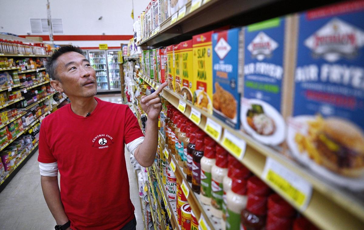 Morgan Doizaki, owner of Central Fish, points out some of the Cajun spices he sells at the landmark business located in Chinatown on Tuesday, April 29, 2025 in Fresno.