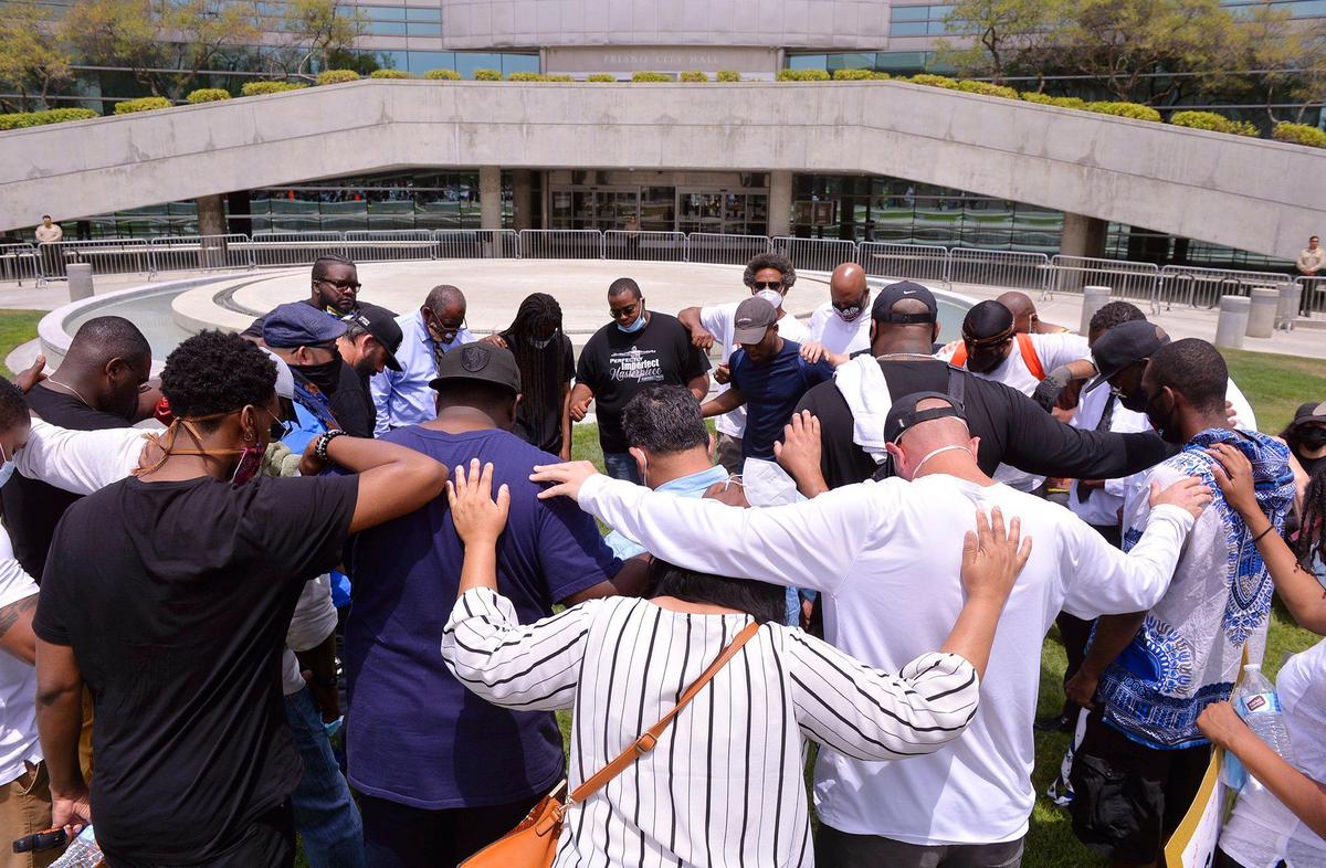 A group prays together before the day’s protest march, which began in front of Fresno City Hall and marched to Fresno Police Department headquarters, on Sunday, May 31, 2020 in downtown Fresno. Local organizers called the march to protest the killing of George Floyd in Minneapolis.
