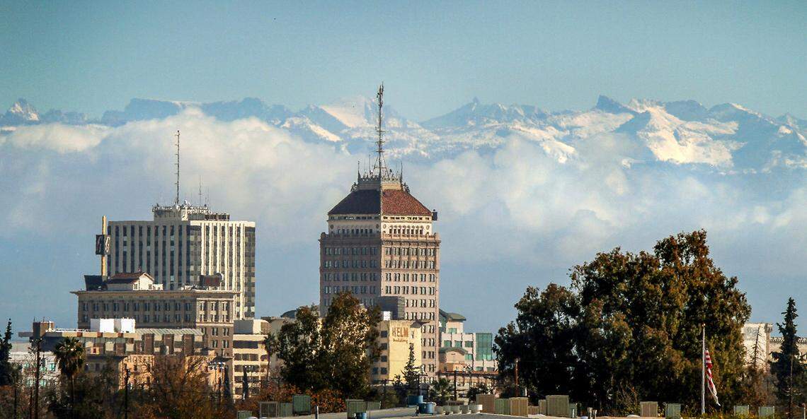 The downtown Fresno skyline is seen in the foreground as snow caps the Sierra Nevada mountains and clouds hug the foothills in the background Monday, Dec. 14, 2009. Several days of precipitation have given the mountains east of Fresno a much-needed dumping of snow. CRAIG KOHLRUSS/THE FRESNO BEE