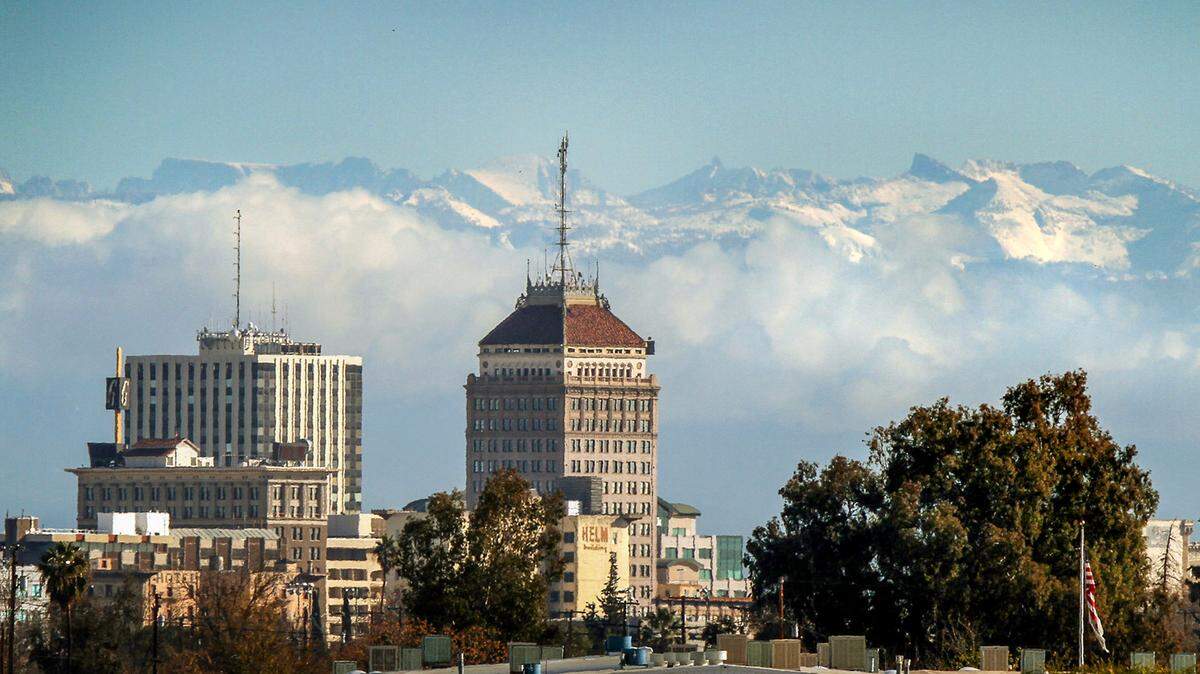 FRESNO, CA 12/14/09 MTD CEK MOUNTAIN SNOW The downtown Fresno skyline is seen in the foreground as snow caps the Sierra Nevada mountains and clouds hug the foothills in the background Monday, December 14, 2009. Several days of precipitation have given the mountains east of Fresno a much-needed dumping of snow. CRAIG KOHLRUSS/THE FRESNO BEE
