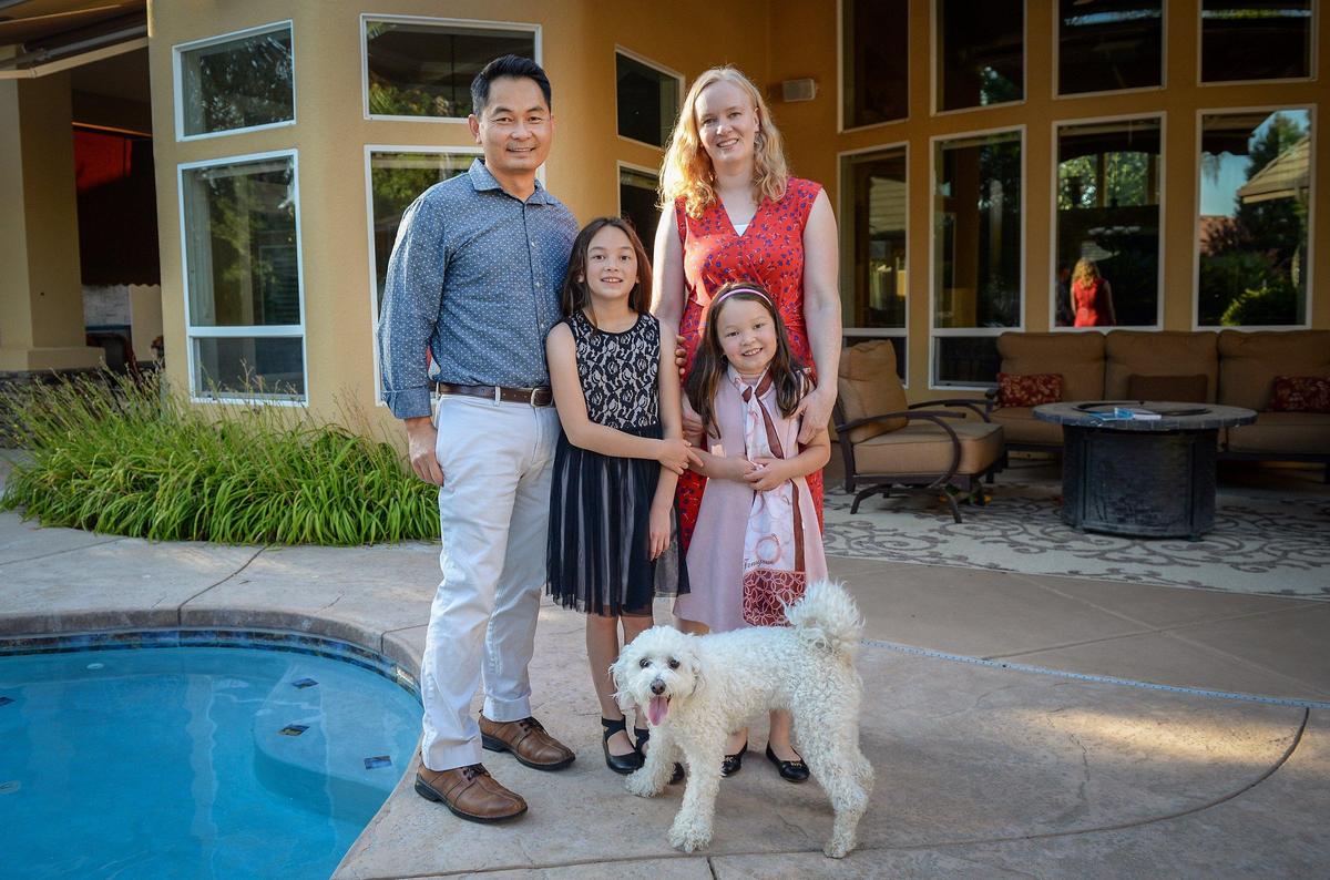 Mikhai Ta, his wife Stephanie Fritz-Ta, and daughters Ellie Ta, 9, left, and Annie Ta, 7, stand in the backyard of their new home in Clovis on Tuesday, June 19, 2019. The family lost most of their possessions after evacuating from their home in Paradise, CA before it burned in last year’s wildfire. After months of living in temporary housing the family settled in Clovis where they were able to buy the former owners’ furnishings.