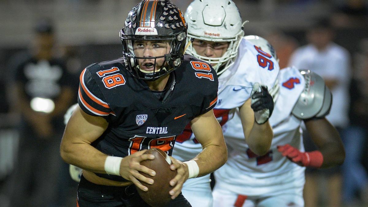 Central quarterback Trent Tompkins, left, takes off down field on a keeper while being chased down by the Buchanan defense in their game at Koligian Stadium on Friday, Sept. 28, 2018.