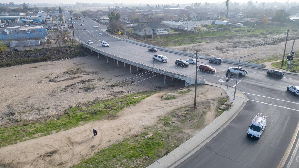 Cars pass over the Cleveland Avenue bridge at the Fresno River in Madera where a homeless encampment has been erected on Thursday, Dec. 19, 2024.