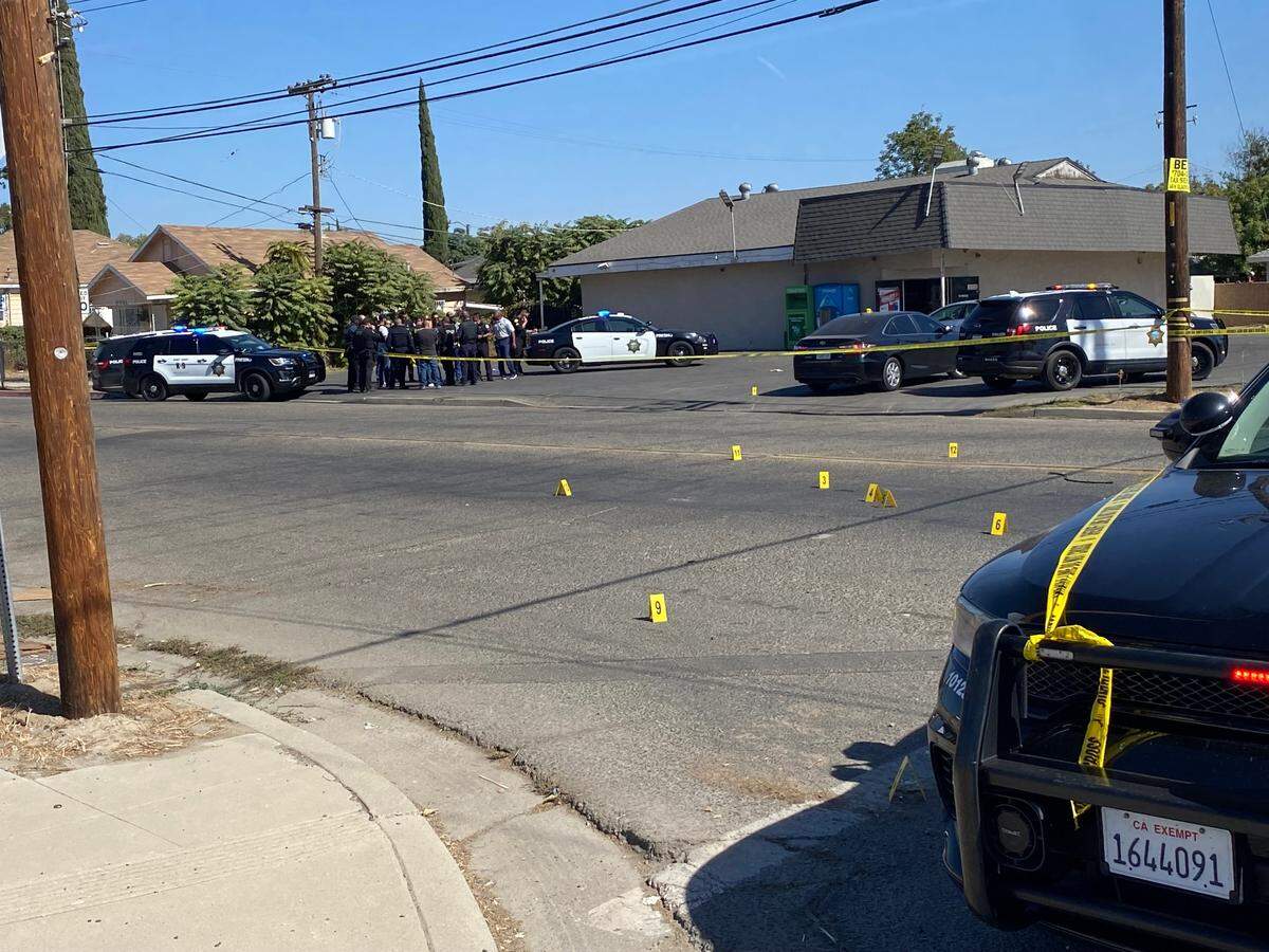 Fresno police overlook the scene where a shooter fired a suspected 23 rounds outside a convenience store, striking one man in the chest on Thursday, Oct. 12, 2023, police said.