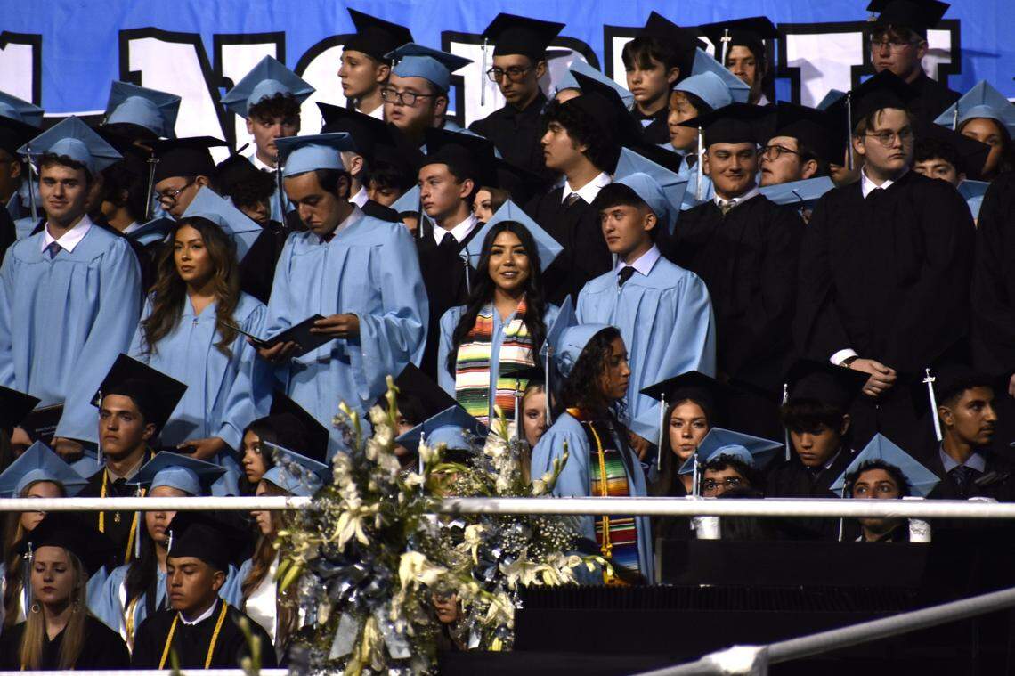 Camila Lemus (centro) sonríe mientras está de pie con sus compañeros de clase después de recibir su diploma y graduarse de Clovis North High School, la noche del martes 4 de junio de 2024. La joven de 17 años tenía dos empleos mientras estudiaba a tiempo completo y era miembro fundador del Latino Club de la escuela y del grupo de baile folclórico Las Caballeras del Norte.