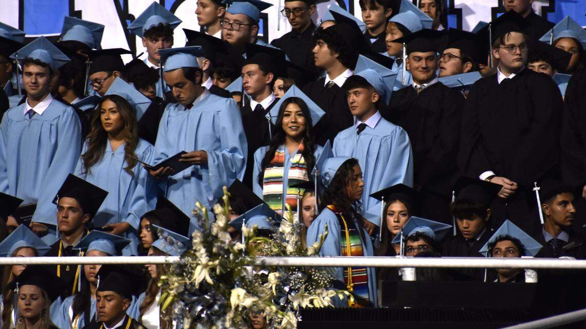 Camila Lemus (center) smiles as she stands with her classmates after receiving her diploma and graduating from Clovis North High School at Veteran’s Memorial Stadium in Clovis on Tuesday night, June 4, 2024. The 17-year-old held two jobs while studying full time and being a founding member of the school’s Latino Club and folklórico dance group, Las Caballeras del Norte. 