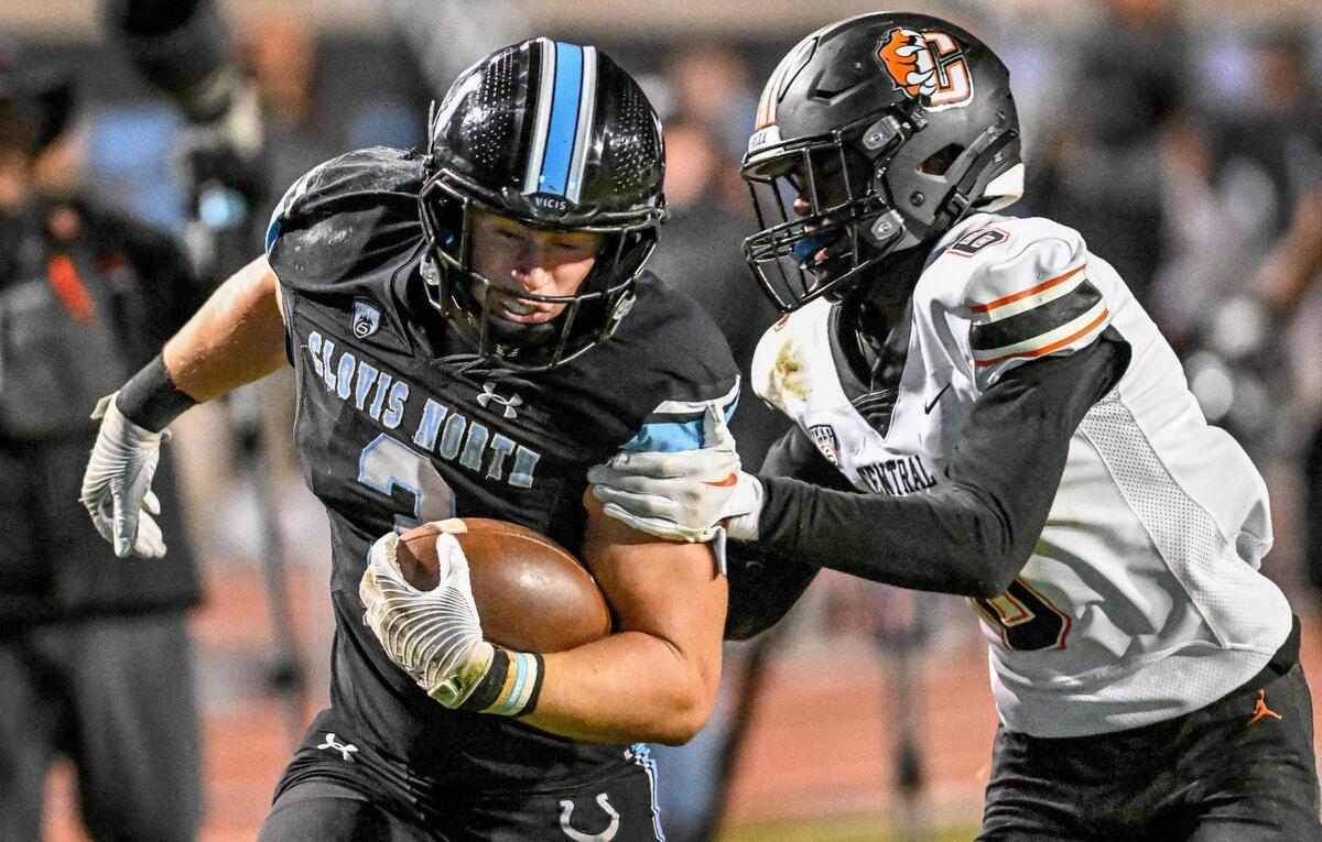 Clovis North running back Mckay Madsen tries to pull away from Central’s Jaylon Jones before scoring the Bronco’s go-ahead touchdown late in their Central Section Division 1 football championship game at Veterans Memorial Stadium in Clovis on Friday, Nov. 24, 2023.