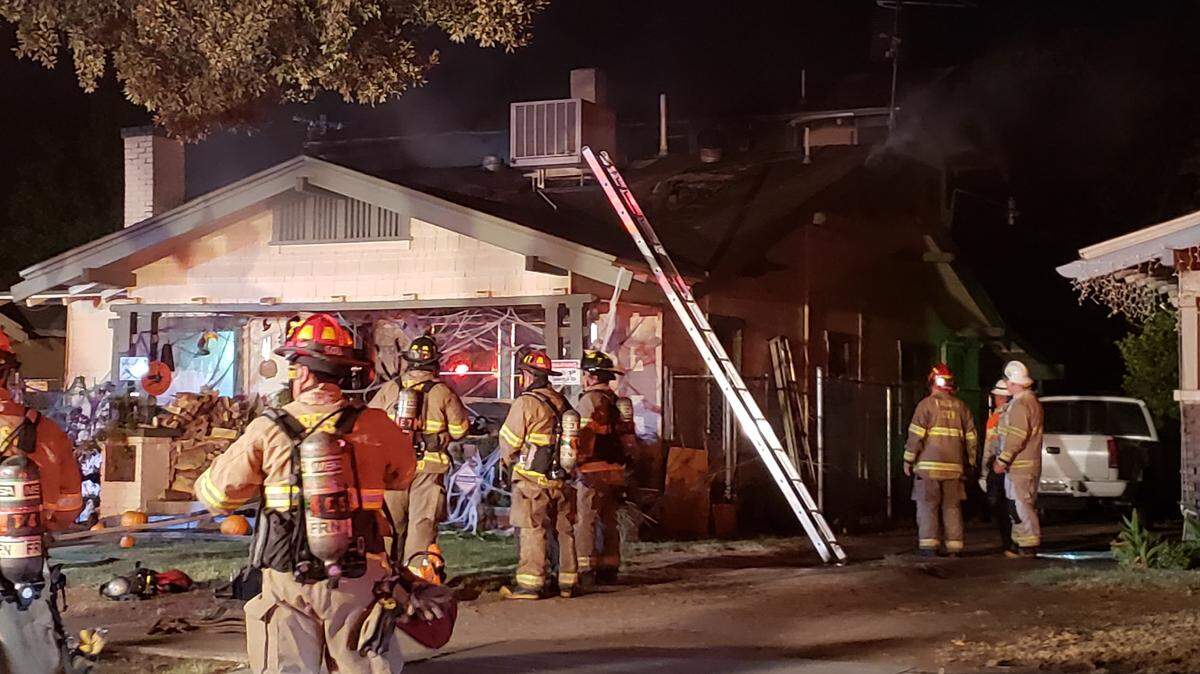 Firefighters assess a southeast Fresno home after a fire on Tuesday, Oct. 16, 2018.