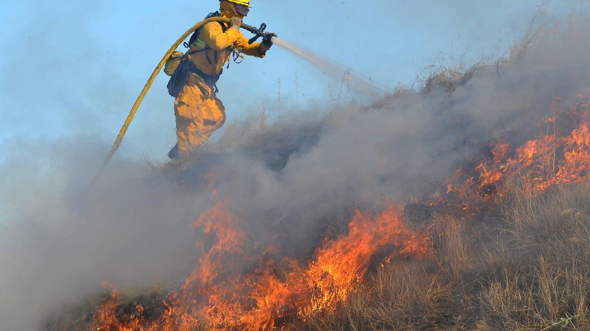 A City of Clovis firefighter puts water on a fire started by a Roman candle during a demonstration of illegal fireworks at the Clovis Fire Department Training Center, Tuesday July 2, 2019, as part of a press conference held by the Central Valley Fireworks Task Force which will enforce a zero-tolerance policy against the possession and use of illegal fireworks this Fourth of July holiday season.