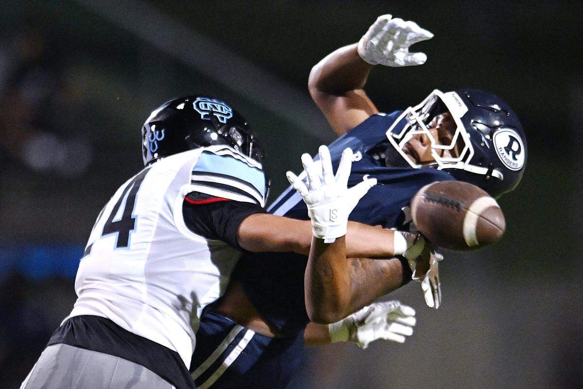 Clovis North's Ben Cazares, left, covers Redwood High's Zephaniah Sesay, right, in a game Friday, Aug. 29, 2025 in Visalia. Clovis North held off Redwood for a 38-34 win.