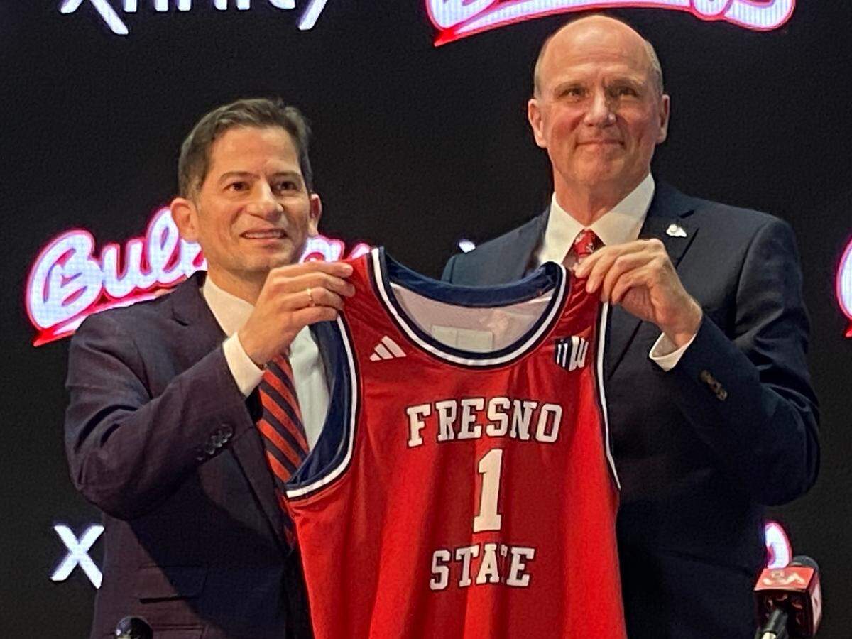Fresno State President Saúl Jiménez-Sandoval, left, and newly hired men’s basketball coach Vance Walberg pose for a photo op during Walberg’s introductory press conference April 12, 2024, at the Josephine Theater.