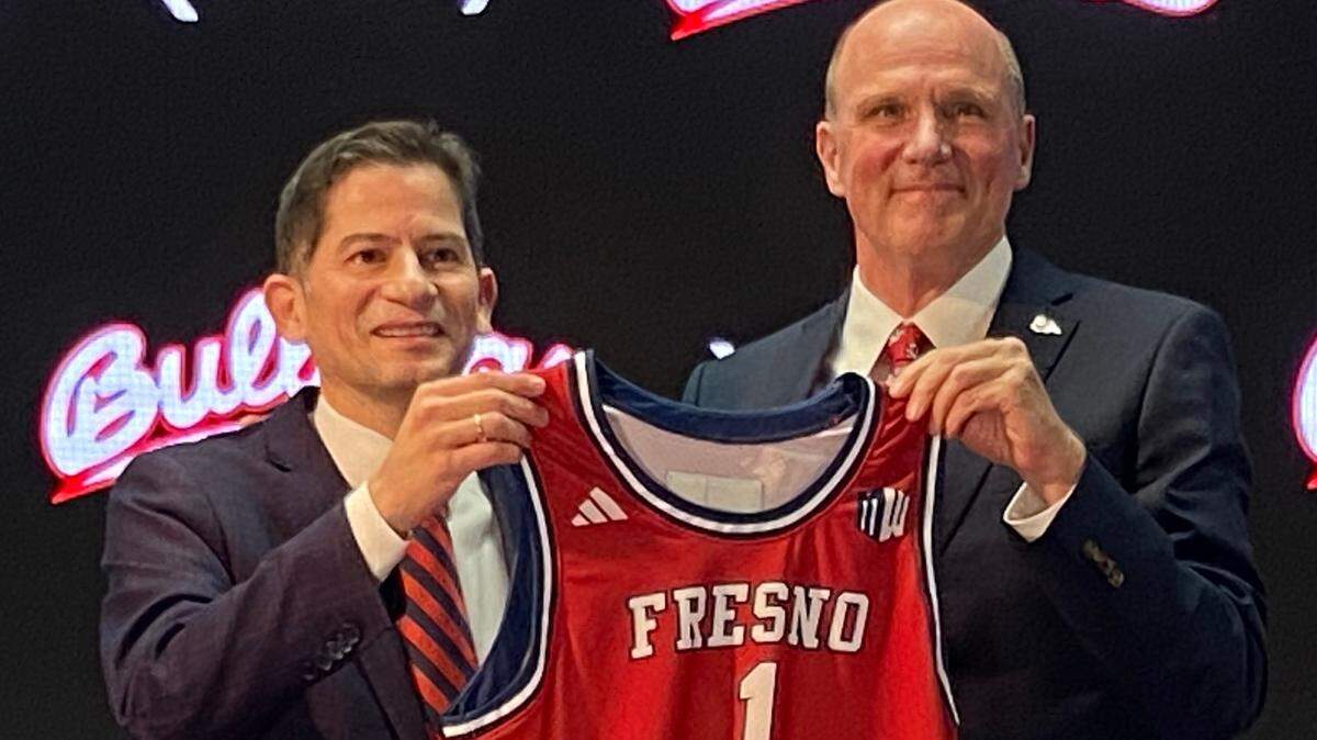 Fresno State President Saúl Jiménez-Sandoval, left, and newly hired men’s basketball coach Vance Walberg pose for a photo op during Walberg’s introductory press conference April 12, 2024, at the Josephine Theater.