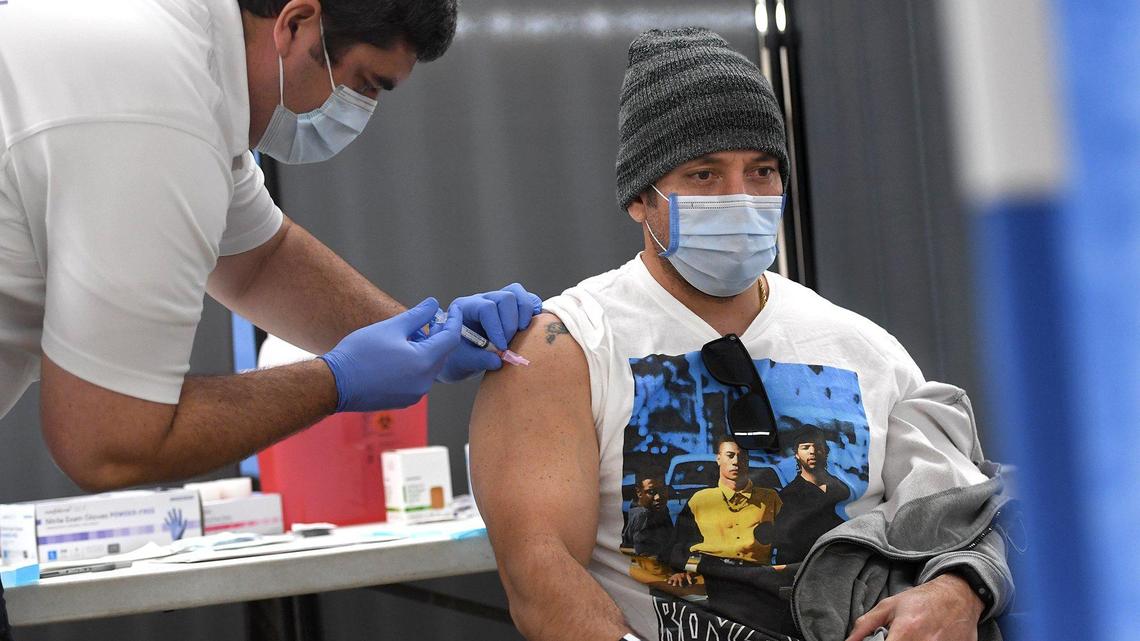 Fresno Fire Capt. Keola Park gets his vaccination from American Ambulance paramedic Jared Case, during the Fresno County Emergency Medical Services COVID-19 vaccination event at the Fresno Fairgrounds, Tuesday Dec. 29. Frontline workers with Fresno County EMS and American Ambulance staff received the shots.