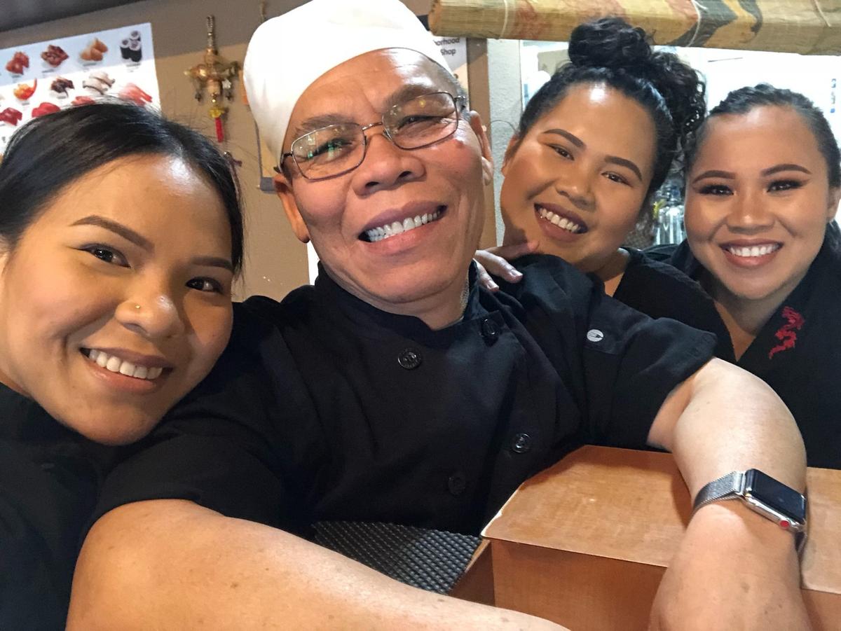 Bo Hatsavongsa poses with his daughters at his old Fresno restaurant, Oishii Japanese Cuisine, where the entire family worked. He said he and wife hoped to teach them the value of hard work when they were young. His daughters earned money while they went to school by serving, washing dishes and crafting sushi.