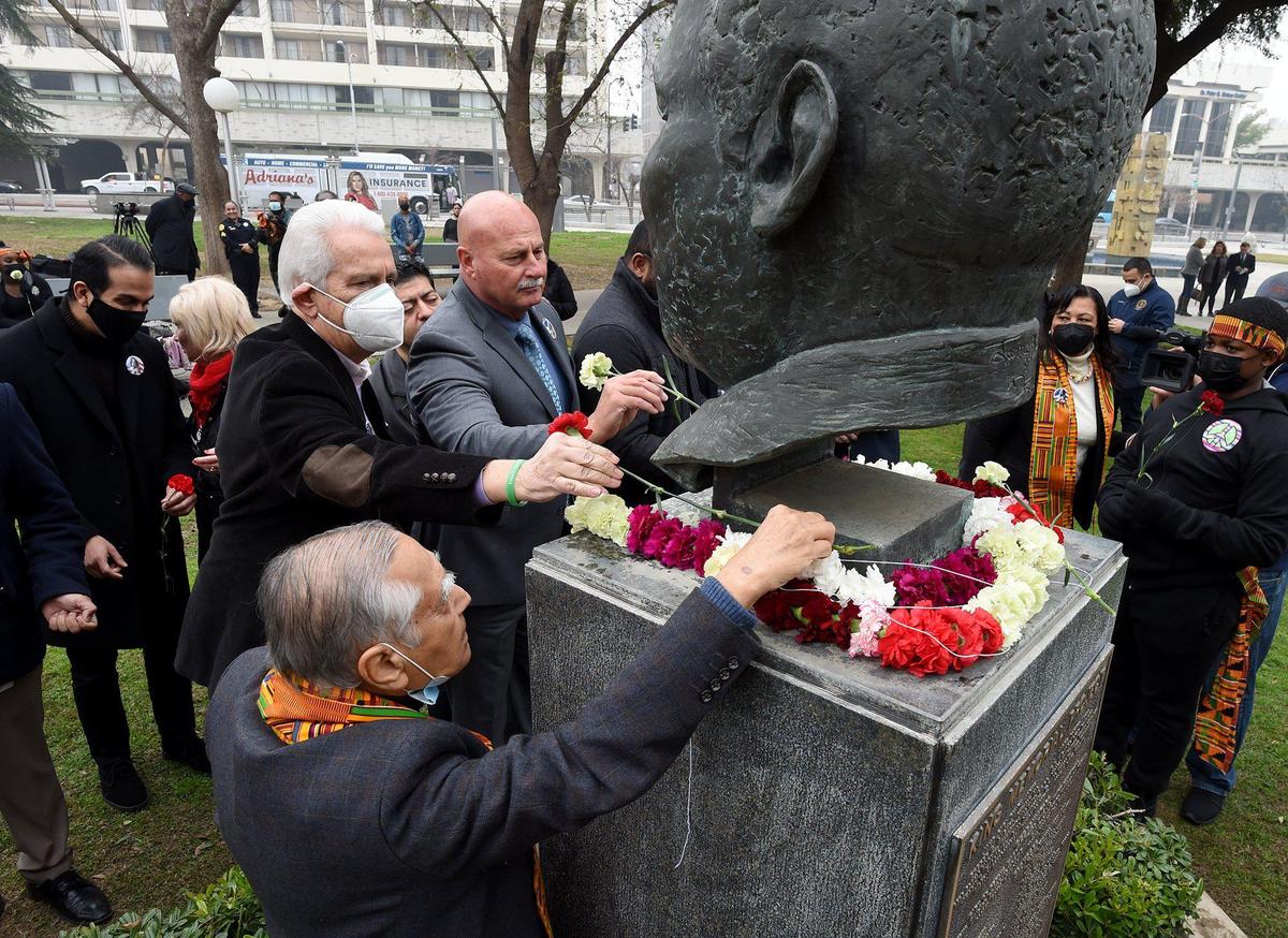 Dr. Sudarshan Kapoor, bottom left, Congressman Jim Costa, left, and Mayor Jerry Dyer, lay carnations at the bust of Rev. Dr. Martin Luther King, Jr.,during garlanding ceremonies to the kick off the 38th annual events to remember and honor the slain civil rights leader, at Courthouse Park, Friday Jan. 14, 2022.